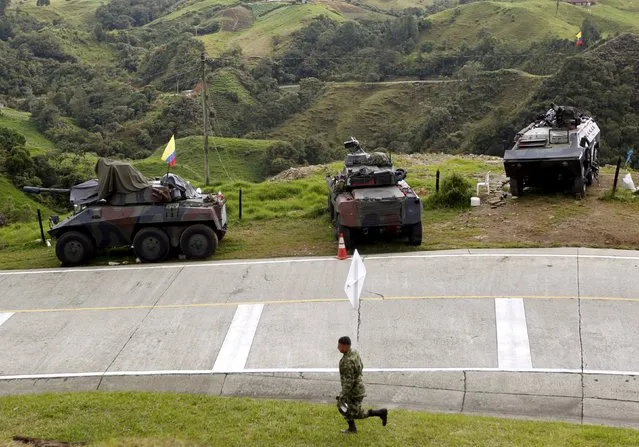 Armored army vehicles are seen on guard along a road close to a zone of landmines planted by rebels groups near Sonson in Antioquia province, November 19, 2015. (Photo by Fredy Builes/Reuters)