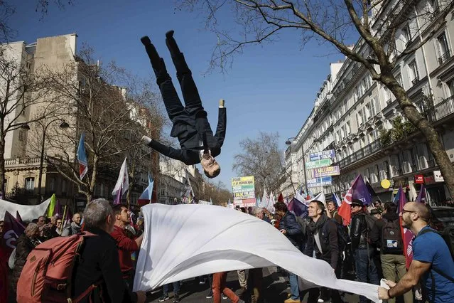 A puppet of French President Emmanuel Macron goes in the air during a march led by far-left candidate for the upcoming presidential election Jean-Luc Melenchon, in Paris, Sunday, March 20, 2022. Jean-Luc Melenchon is rising in the polls ahead of April 10 and 24 election. (Photo by Thomas Padilla/AP Photo)