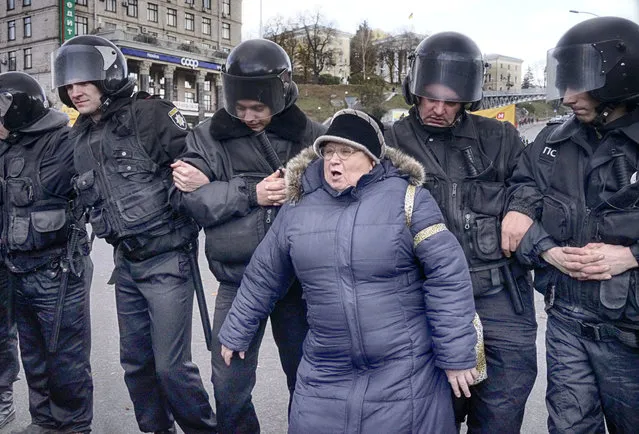 Riot police hold back bank clients as they block traffic during a protest rally in Khreshchatyk Street, Kiev, Ukraine, Thursday, November 3, 2016. A few hundred clients of a Kiev-based bank, that has been announced insolvent, demanded that the government return their deposits. (Photo by Efrem Lukatsky/AP Photo)