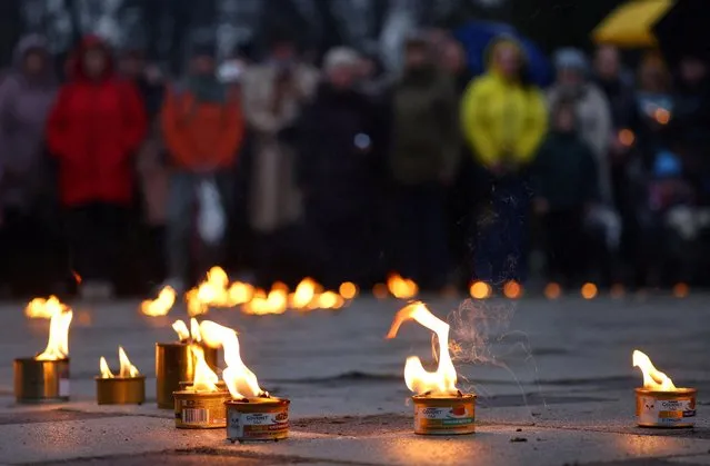 People attend a vigil marking the first anniversary of the liberation of the town of Bucha, amid Russia’s attack on Ukraine in Bucha, outside Kyiv, Ukraine on March 31, 2023. Kyiv says more than 1,400 people were killed in Bucha during the occupation including 37 children, more than 175 people were found in mass graves and torture chambers, and 9,000 Russian war crimes have been identified. (Photo by Kai Pfaffenbach/Reuters)
