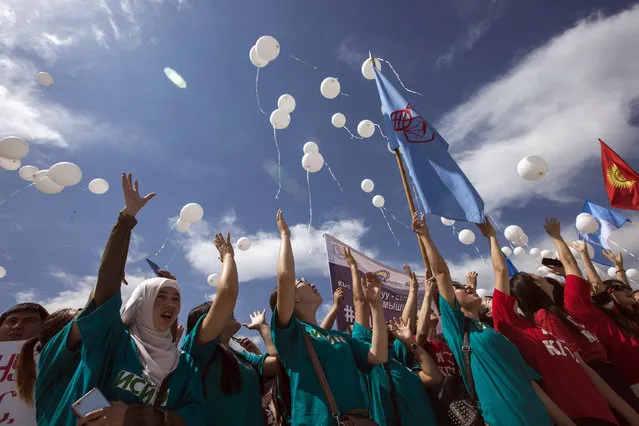 Kyrgyz students release white balloons as they protest against bride kidnapping in downtown Bishkek on June 6, 2018. More than a thousand people including schoolchildren protested against bride kidnapping in Kyrgyzstan on June 6, 2018, after a 20-year-old woman was murdered in a police station by her kidnapper. (Photo by Dmitry Motinov/AFP Photo)