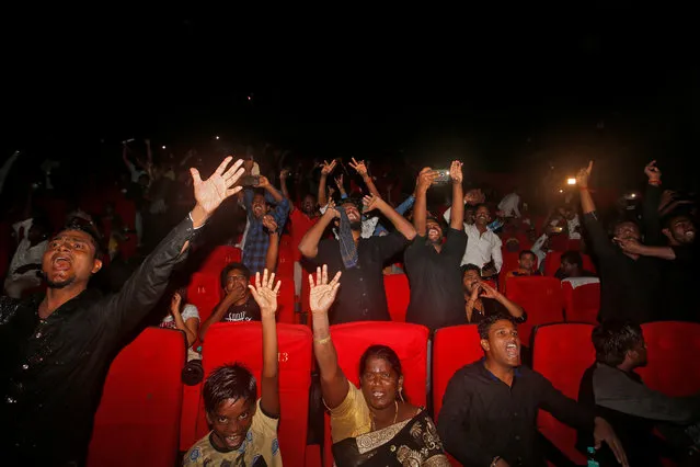 Fans react upon seeing actor Rajinikanth in a scene during his new movie “Kaala” inside a cinema hall in Mumbai, India, June 7, 2018. (Photo by Francis Mascarenhas/Reuters)