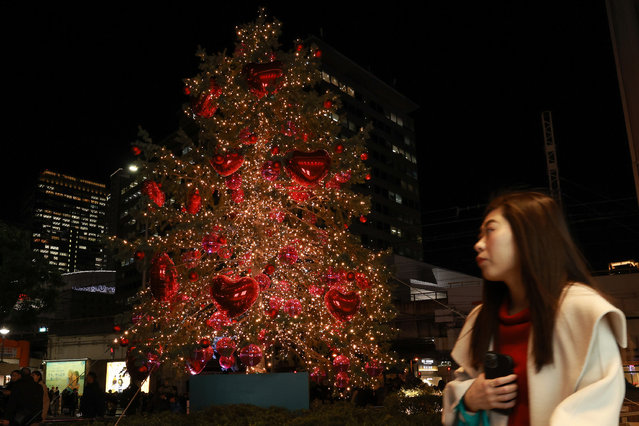 A woman walks past the holiday decorations during the Christmas shopping season on December 18, 2025 in Osaka, Japan. (Photo by Buddhika Weerasinghe/Getty Images)