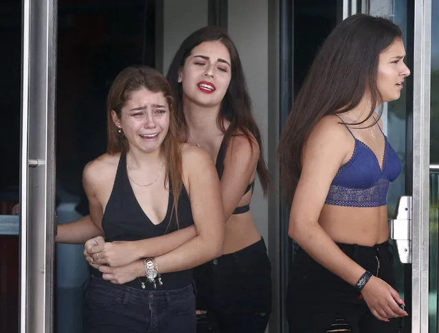Three girls weep after they view a memorial for the rapper XXXTentacion, Wednesday, June 27, 2018, in Sunrise, Fla. The rapper was gunned down in a luxury sports car last week. (Photo by Brynn Anderson/AP Photo)