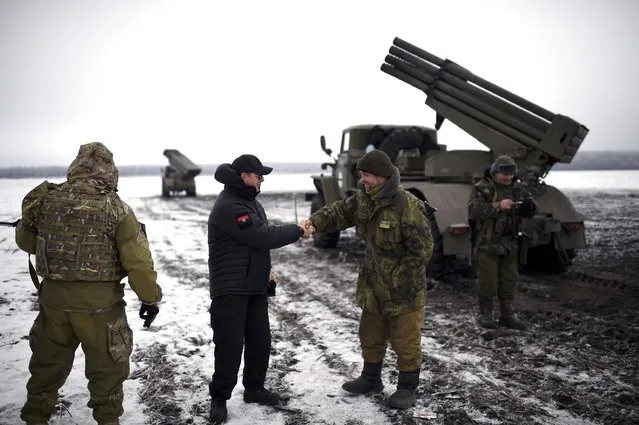 In this Sunday, January 25, 2015 pool photo, Ukrainian parliament lawmaker and leader of Ukraine's Radical Party Oleh Lyashko, second left, greets Ukrainian soldiers while visiting their position near the town of Volnovakha, in eastern Ukraine. (Photo by Osman Karimov/AP Photo)