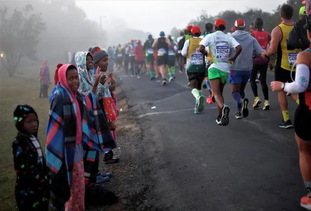 People cheer, as runners competing in the Comrades Marathon pass through Ashburton, South Africa on June 11, 2023. (Photo by Rogan Ward/Reuters)