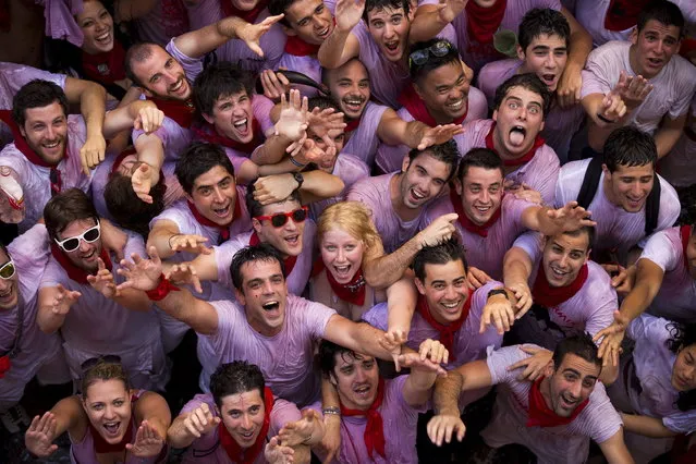 Revelers react while they ask for water to be thrown from balconies during the launch of the “Chupinazo” rocket, to celebrate the official opening of the 2013 San Fermin fiestas, Saturday, July 6, 2013 in Pamplona, Spain. (Photo by Daniel Ochoa de Olza/AP Photo)