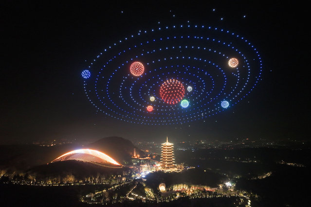 Drones with lights perform over a pagoda during a New Year celebration in Nanjing city in east China's Jiangsu province Tuesday, December 31, 2024. (Photo by Fang Dongxu/Future Publishing via Getty Images)