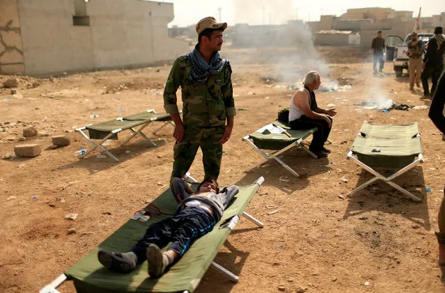 Displaced people receive treatment from Iraqi soldiers at Samah neighborhood after they were wounded during a fight between the Islamic State militants and the Iraqi Counter Terrorism Service, in Mosul November 13, 2016. (Photo by Ahmad Jadallah/Reuters)