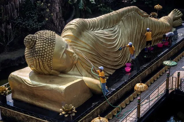 Workers clean a Buddha statue at Maha Vihara Mojopahit temple in Mojokerto on May 30, 2023, ahead of the Vesak festival which commemorates the birth, enlightenment and death of Buddha. (Photo by Juni Kriswanto/AFP Photo)