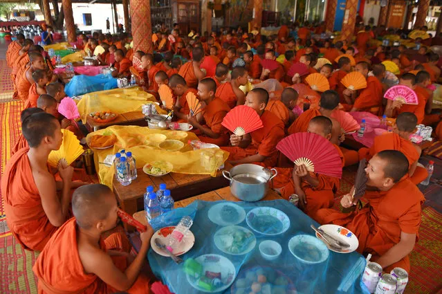 Young Buddhist monks pray before lunch at a temple in Samrong district in Cambodia's Takeo province on the outskirts of Phnom Penh on January 23, 2021. (Photo by Tang Chhin Sothy/AFP Photo)