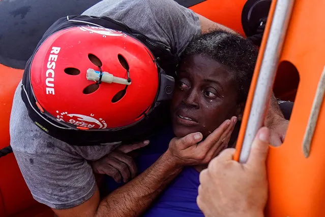 A crew member of NGO Proactiva Open Arms rescue boat embraces African migrant in central Mediterranean Sea, July 17, 2018. (Photo by Juan Medina/Reuters)