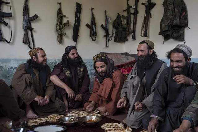 Taliban fighters enjoy lunch inside an adobe house that is used as a makeshift checkpoint in Wardak province, Afghanistan, Thursday June 22, 2023. (Photo by Rodrigo Abd/AP Photo)