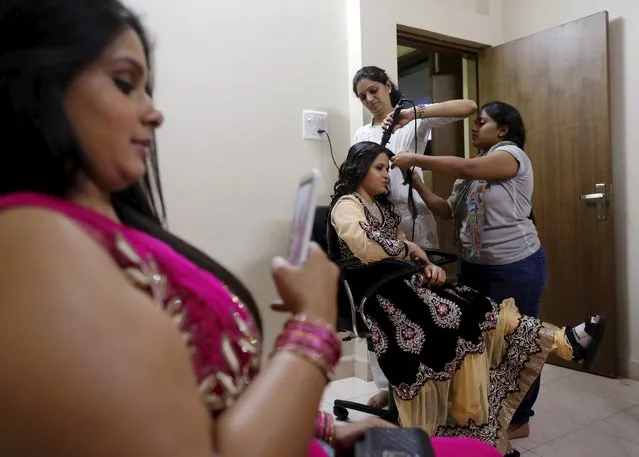 A participant has her makeup done by her relatives backstage during the Mr & Miss Wheelchair India competition in Mumbai, India, December 20, 2015. Nine men and four women from across India participated in the competition, which aims to open doors for the wheelchair-bound in modelling, film and television, according to its organisers. (Photo by Danish Siddiqui/Reuters)