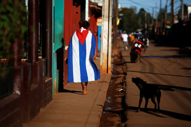 A dog barks at a person wearing a Cuban flag in the town of Alquizar, Cuba August 6, 2018. (Photo by Tomas Bravo/Reuters)