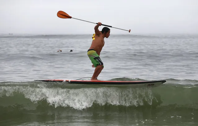 A man surf on his “Stand Up Paddle Board” in Punta Hermosa beach in Lima, Peru, Saturday, February 7, 2015. (Photo by Martin Mejia/AP Photo)