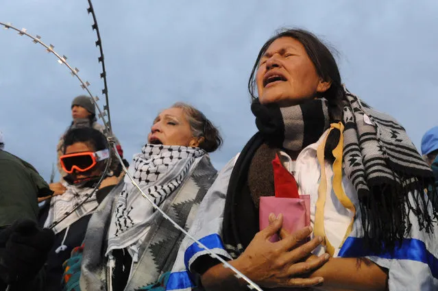 Women hold a prayer ceremony on Backwater Bridge during a protest against plans to pass the Dakota Access pipeline near the Standing Rock Indian Reservation, near Cannon Ball, North Dakota, U.S. November 27, 2016. (Photo by Stephanie Keith/Reuters)