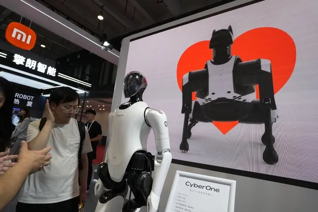 A human like cyborg and an image of a robot dog is displayed at the Xiaomi booth at the annual World Robot Conference at the Beijing Etrong International Exhibition and Convention Center in Beijing, Wednesday, August 16, 2023. (Photo by Ng Han Guan/AP Photo)