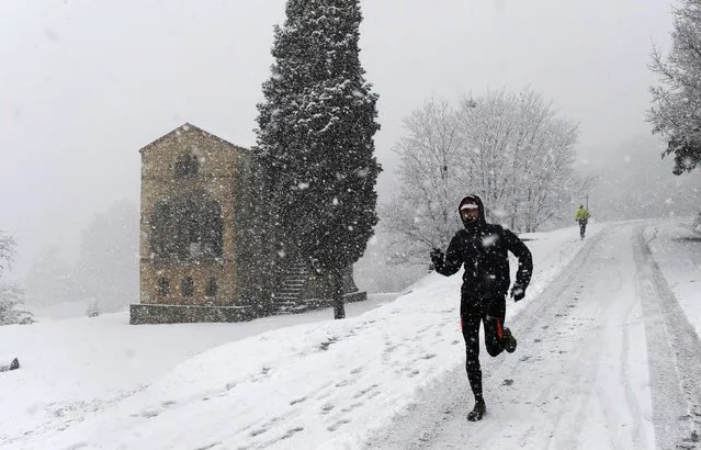 A man runs, as he records with his video camera, during the snowstorm in mount Naranco in Oviedo, northern Spain,  February 6, 2015. (Photo by Eloy Alonso/Reuters)