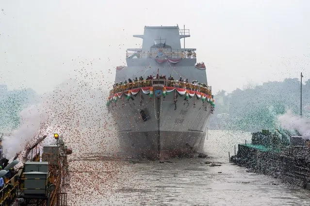 Confetti and smoke in the colors of the Indian national flag mark the entry of INS Vindhyagiri, a new warship for the Indian navy, into the Hooghly river in Kolkata, India, Thursday, August 17, 2023. This P17A series warship, built by the Garden Reach Shipbuilders and Engineers in Kolkata, was launched by the Indian President Droupadi Murmu Thursday. (Photo by Bikas Das/AP Photo)