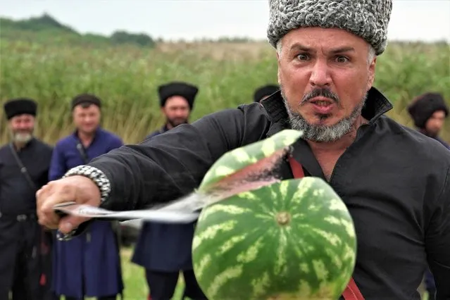 A Cossack slashes a watermelon with a sabre during a sabre-cutting competition in the village of Novosvetlovsky, Rostov region, on August 27, 2023. (Photo by AFP Photo/Stringer)