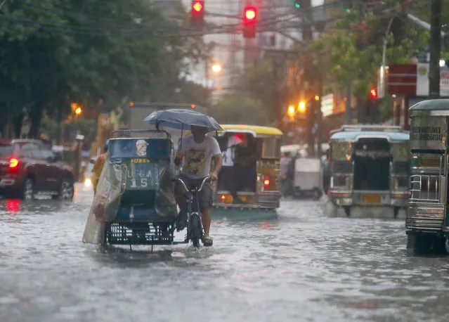 In this August 26, 2016 file photo, commuters and motorists go on their way as heavy monsoon rains inundate low-lying areas in Manila, Philippines. Typhoons that slam into land in the northwestern Pacific – especially the biggest tropical cyclones of the bunch – have gotten considerably stronger since the 1970s, a new study concludes. (Photo by Bullit Marquez/AP Photo)