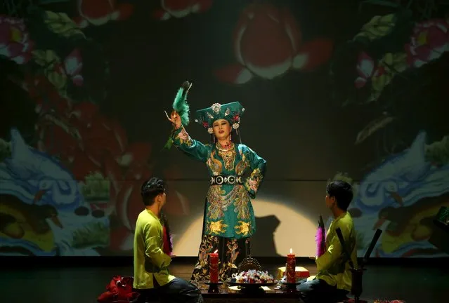 A Vietnamese artist acting as a medium, performs the "Hau Dong" ritual at Viet Theatre in Hanoi January 16, 2016. For the first time, Vietnamese drama director Viet Tu has brought the ritual from religious temples to the theatre partly to draw tourists. The "Hau Dong" is a ritual where a medium puts on special costumes and tells stories of gods and heroes while being accompanied by "Chau Van" music, as part of the act of Dao Mau - the worship of mother goddesses in Vietnam. (Photo by Reuters/Kham)