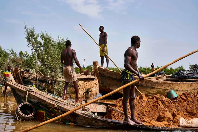 Malian diggers stand on their boats loaded with sand at an extraction site on a affluent of the Niger River near Kangaba, in Mali' s southwestern Koulikoro region, on October 2, 2018. (Photo by Michele Cattani/AFP Photo)