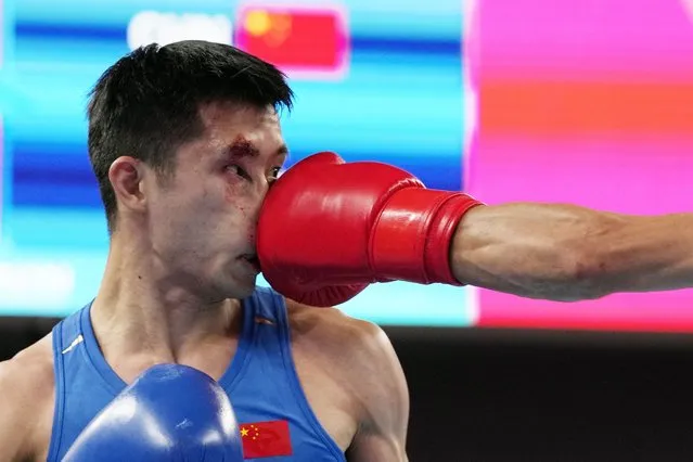 Lyu Ping of China, left, takes a punch from Abdumalik Khalokov of Uzbekistan, right, during boxing Men's 51-57Kg semifinal match at the 19th Asian Games in Hangzhou, China, Hangzhou, Wednesday, October 4, 2023. (Photo by Aijaz Rahi/AP Photo)