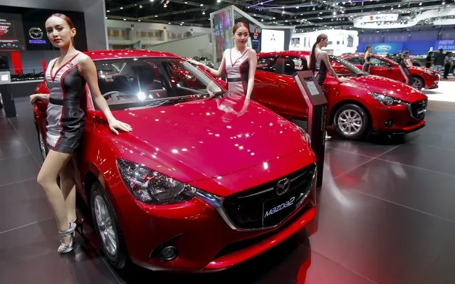 Models pose beside a Mazda 2 during a media presentation of the 36th Bangkok International Motor Show in Bangkok March 24, 2015. (Photo by Chaiwat Subprasom/Reuters)