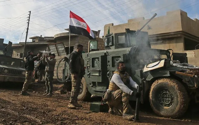 Iraqi pro- government forces advance in Mosul' s southeastern Sumer neighbourhood on December 29, 2016, during an ongoing military operation against Islamic State (IS) group jihadists. Iraqi forces advanced after declaring a new phase in their offensive on eastern Mosul, stepping up efforts to reclaim the Islamic State group' s last major stronghold in the country. (Photo by Ahmad Al- Rubaye/AFP Photo)