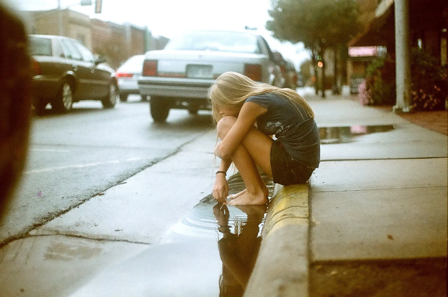 Совсем неожиданно. Девушка сидит на дороге. Девушка сидит на тротуаре. Блондинка на дороге. Девушка сидит на асфальте.