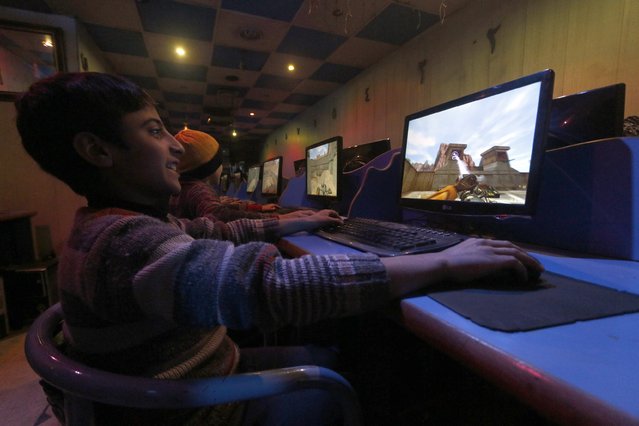 Youths play first-person shooter games inside an internet cafe in Aleppo January 9, 2015. (Photo by Hosam Katan/Reuters)