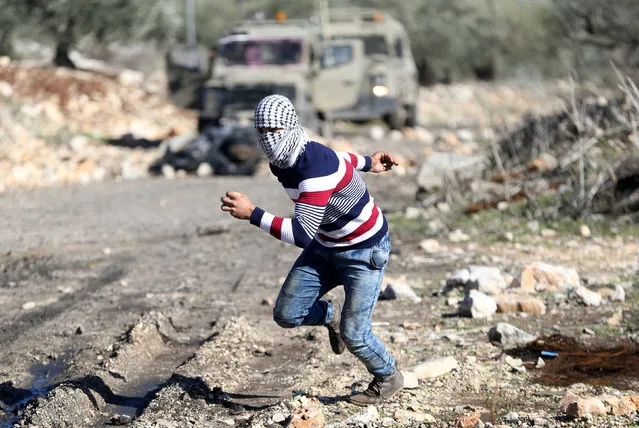 A Palestinian protester runs for cover during clashes with Israeli troops following a protest against the near-by Jewish settlement of Qadomem, in the West Bank village of Kofr Qadom near Nablus December 30, 2016. (Photo by Mohamad Torokman/Reuters)