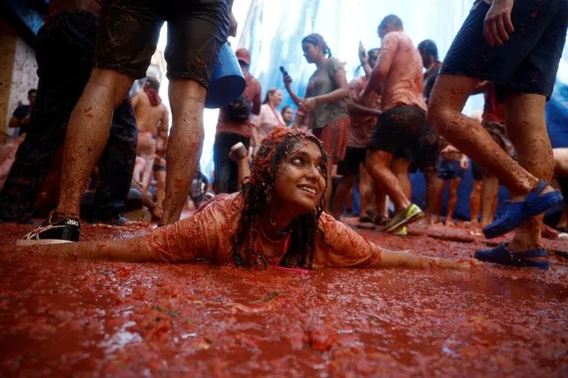 Revelers play in tomato pulp during the annual “La Tomatina” food fight festival in Bunol, Spain on August 31, 2022. (Photo by Juan Medina/Reuters)