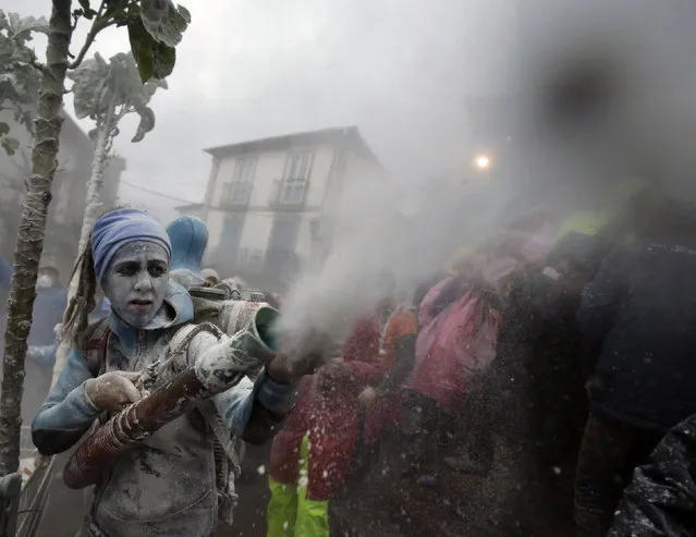 Revellers participate in a flour fight during the “O Entroido” festival in Laza village Spain February 8, 2016. The carnival lasts for a week and is considered a major social and cultural event in Laza. (Photo by Miguel Vidal/Reuters)