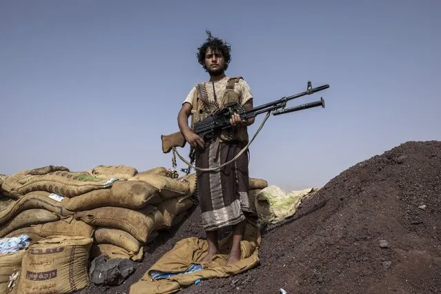 Yemeni fighter Hassan Saleh backed by the Saudi-led coalition stands for a photograph after clashes with Houthi rebels on the Kassara front line near Marib, Yemen, Sunday, June 20, 2021. Saleh and his younger brother Saeed, both in their early 20s, both in their early 20s, have been fighting alongside other government fighters and tribesman outside the oil-rich city of Marib against the months-long offensive by the Iranian-backed rebels. They say they need more weapons to push the attackers back. (Photo by Nariman El-Mofty/AP Photo)