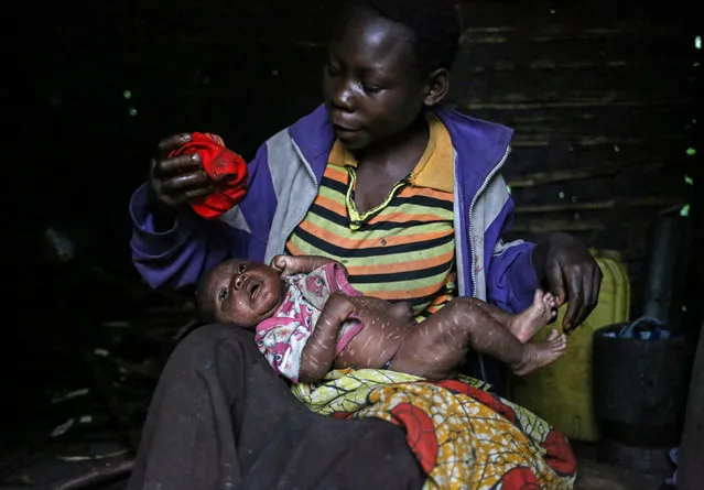 Mwenyezi, 36, washes her baby who is suffering from fever, at Kagorwa Pygmy camp on Idjwi island in the Democratic Republic of Congo, November 24, 2016. Mwenyezi cannot afford to take her baby for medical care. Her baby has scars from “bleeding”, which some Pygmies use to try and treat certain diseases. (Photo by Therese Di Campo/Reuters)