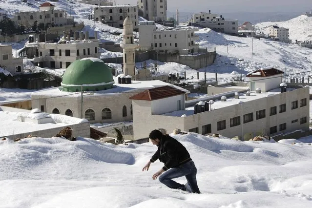 A Palestinian walks on snow  to reach to his home in the West Bank city of Nablus, Sunday, December 15, 2013. The Gaza Strip received its first shipment of industrial fuel in 45 days Sunday. A lack of fuel has hampered rescue efforts in Gaza, where thousands of residents fled flooded homes. The storm let up Saturday, but authorities in the region still struggled to clear roads and repair downed power lines. (Photo by Nasser Ishtayeh/AP Photo)