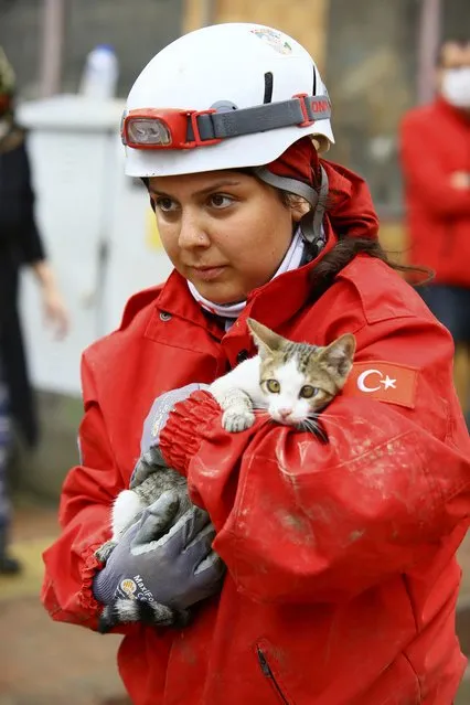 A rescue worker holds a kitten she saved from a building in Bozkurt town of Kastamonu province, Thursday, August 12, 2021. The floods triggered by torrential rains battered the Black Sea coastal provinces of Bartin, Kastamonu, Sinop and Samsun on Wednesday, demolishing homes and bridges and sweeping cars away by torrents. Helicopters scrambled to rescue people stranded on rooftops. (Photo by IHA via AP Photo)
