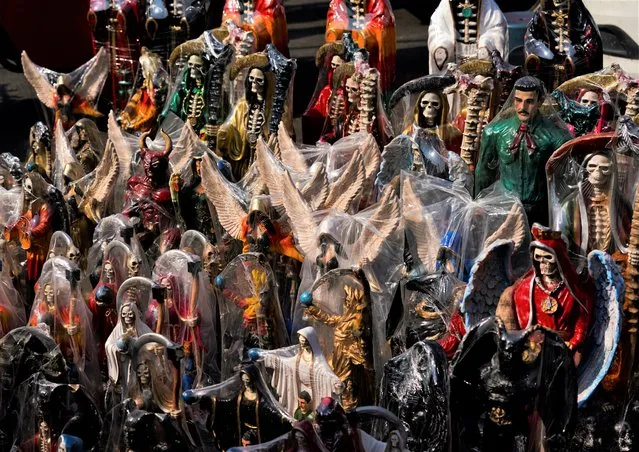 Vendors display ornately decorated statuettes of “Nuestra Señora de la Santa Muerte”, or Our Lady of Holy Death, in Mexico City's Tepito neighborhood, Tuesday, November 1, 2022. La Santa Muerte, is a cult image and folk saint, a personification of death, associated with healing, protection, and safe delivery to the afterlife by her devotees. (Phoot by Fernando Llano/AP Photo)