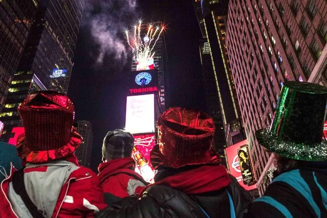 People look towards fireworks exploding from Times Square's New Year's Eve Ball during New Year's Eve celebrations at Times Square in New York, December 31, 2013. (Photo by Zoran Milich/Reuters)