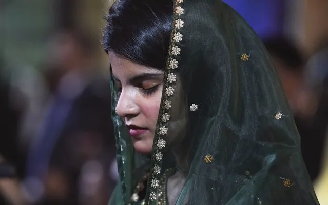 A woman attends midnight Christmas mass at St. Andrew's Church in Karachi, Pakistan, Sunday, December 24, 2023. (Photo by Fareed Khan/AP Photo)