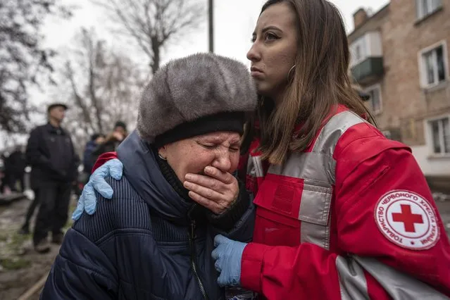A woman cries in front of the building which was destroyed by a Russian attack in Kryvyi Rih, Ukraine, Friday, December 16, 2022. Russian forces launched at least 60 missiles across Ukraine on Friday, officials said, reporting explosions in at least four cities, including Kyiv. At least two people were killed by a strike on a residential building in central Ukraine, where a hunt was on for survivors. (Photo by Evgeniy Maloletka/AP Photo)