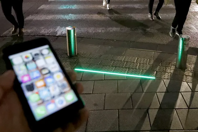 A picture taken on March 12, 2019 shows LED ground level lights installed to warn texting pedestrians before crossing the road in the coastal city of Tel Aviv. (Photo by Jack Guez/AFP Photo)