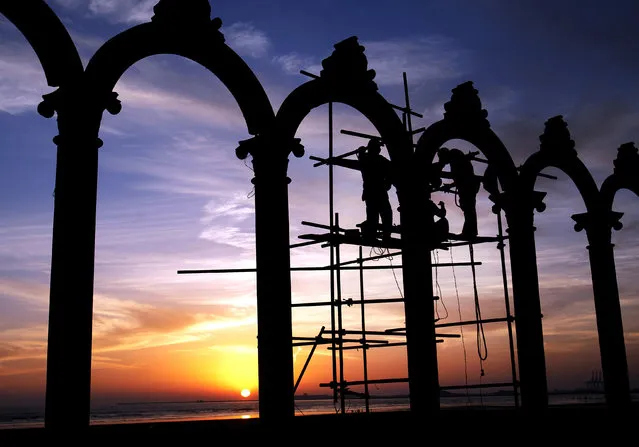 Pakistani labors work on arches constructed at Clifton beach in Karachi, Pakistan, Wednesday, February 24, 2016. (Photo by Shakil Adil/AP Photo)