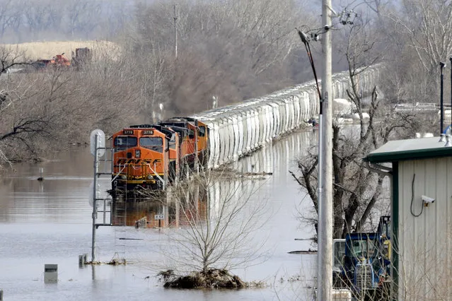 A BNSF train sits in flood waters from the Platte River, in Plattsmouth, Neb., Sunday, March 17, 2019. Hundreds of people remained out of their homes in Nebraska, but rivers there were starting to recede. The National Weather Service said the Elkhorn River remained at major flood stage but was dropping. (Photo by Nati Harnik/AP Photo)