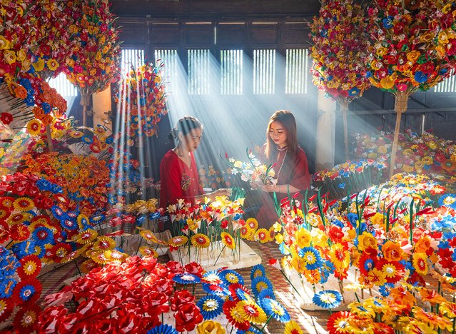Women work on a colourful display of paper flowers ready to be showcased during the traditional Tet Nguyen Dan festival in Thanh Tien, Vietnam early February 2024. Tet celebrates the arrival of Spring according to the Vietnamese calendar, often celebrated in the early weeks of February, and is this year being held on February 10. (Photo by Nguyen Sanh Quoc Huy/Solent News)