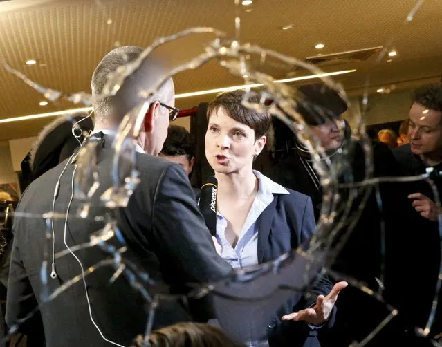 Frauke Petry, chairwoman of the anti-immigration party Alternative for Germany (AfD) is pictured through a broken window after first exit polls in three regional state elections at the AfD party's election night party in Berlin, Germany, March 13, 2016. (Photo by Fabrizio Bensch/Reuters)