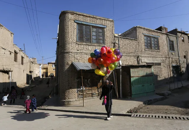 An Afghan man holds balloons for sale in Kabul, Afghanistan March 8, 2016. (Photo by Mohammad Ismail/Reuters)